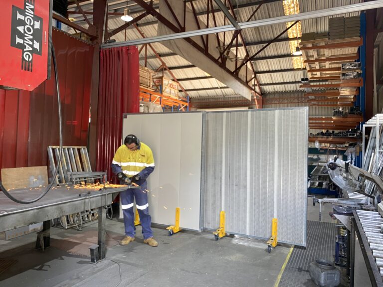 Industrial worker in a factory with hearing protection, and Sonic System acoustic mobile