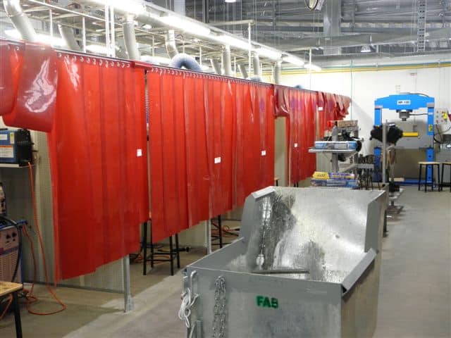 Acoustic welding bay with a tank in the front of the bays
