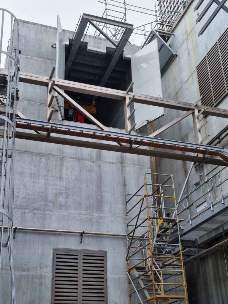 Custom Rw46 Sonic Access double doors, designed to integrate into a reduced height opening below the existing gantry crane beams.