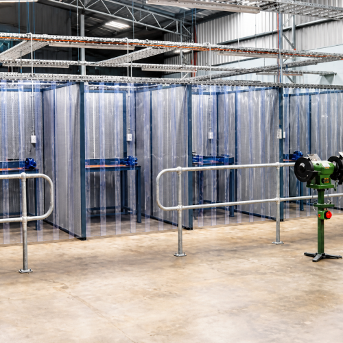 Flexshield grinding bays with Sonic System acoustic modular panels and SonicClear curtains in an industrial workshop.