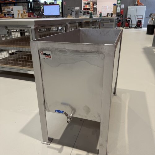 Flexshield Quench tank with stainless steel body, raised legs and front drain tap in an industrial workshop