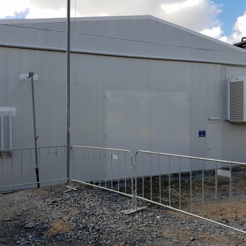 White industrial building with Sonic Access acoustic double doors and a smaller personnel door at Fosterville Gold.