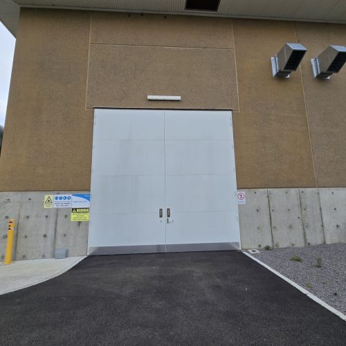 Large white Sonic Access acoustic double doors installed at the entrance to a pump gallery.