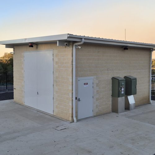 Large white Sonic Access acoustic double doors and personnel door installed on an industrial building.