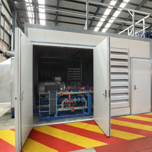 Sonic acoustic enclosure with double doors around industrial machinery