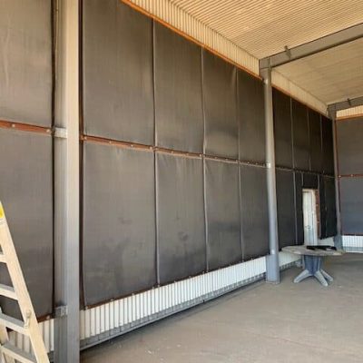 Installation of Flexshield Sonic Quilts with the Safety orange side facing the wall, optimising noise absorption towards the noise source, enhancing the acoustic environment of the facility.