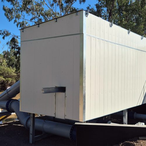 Large Sonic acoustic enclosure installed around water infrastructure beside a river