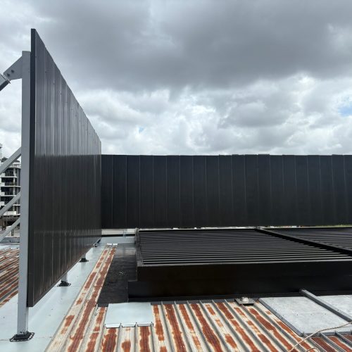 Rooftop acoustic wall with steel support framing around mechanical equipment