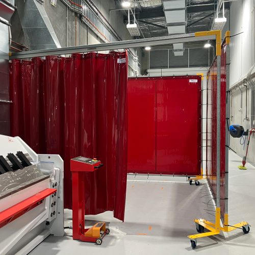 Weldflex™ mobile screens with red welding curtains in an industrial workshop
