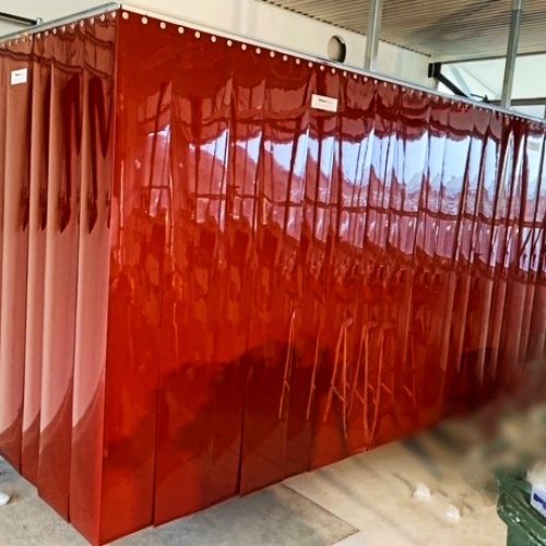 Red transparent Weldflex™ Strip Curtains forming a three-sided enclosure inside an industrial workspace.