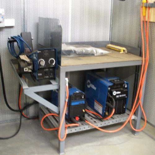 Flexshield Welding tables with integrated equipment storage and steel work surface in a workshop welding bay